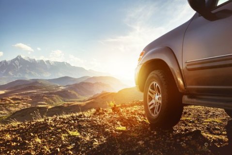 Car driving in mountains  toward sun